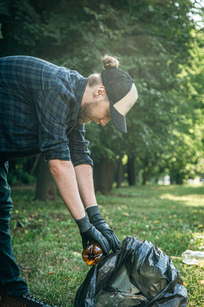 istock A young man with a trash bag in the forest cleans up plastic bottles. 1420981116