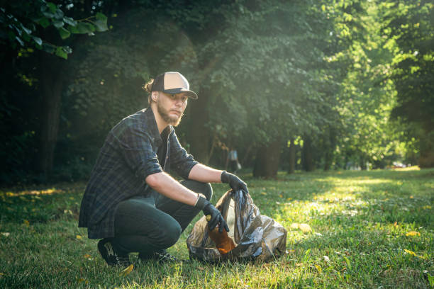 istock A young man with a trash bag in the forest cleans up plastic bottles. 1420981118