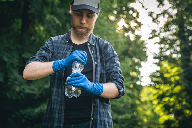 istock A man in gloves with a plastic bottle in his hands cleans the forest. 1420981131