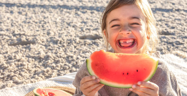 istock Close-up, little girl eats watermelon on the beach. 1420981922
