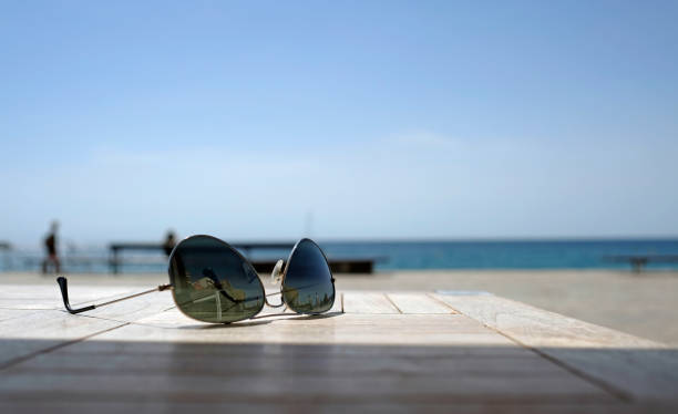 istock Sunglasses on a table near the coast 1420982724