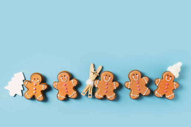 istock Row gingerbrads men on stick on blue background 1420983120