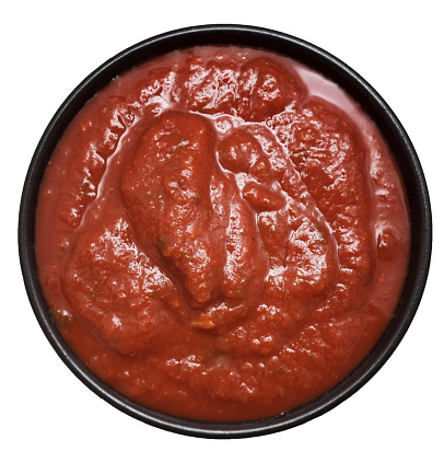 Top view of tomato sauce in a bowl on white background