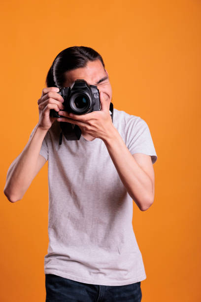 istock Photographer taking photos on professional camera, looking in viewfinder 1420985447