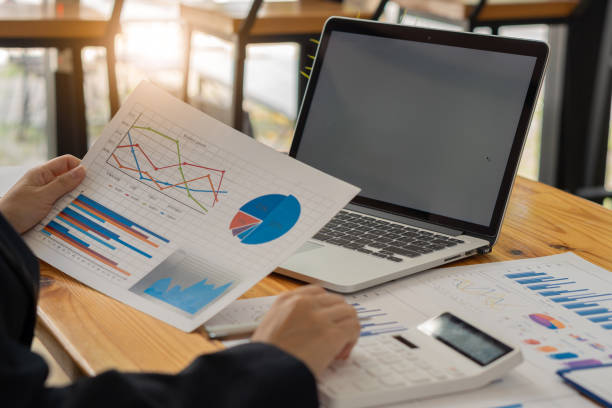 istock businessman holding pen with laptop graphing documents financial calculator deck for calculations and analysis 1420985497