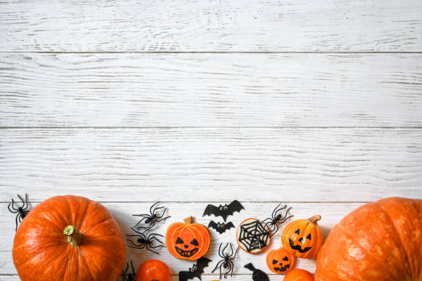istock Halloween background, top view. Pumpkins and sweets on white wooden table, flat lay. 1420986617