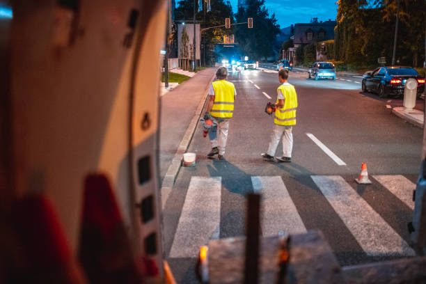istock Construction Crew Spray Painting The Road Signs 1420989687