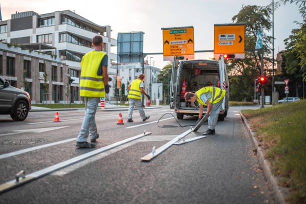 istock Road Maintenance Workers Setting Up A Stencil For Spray Painting The Road 1420990534