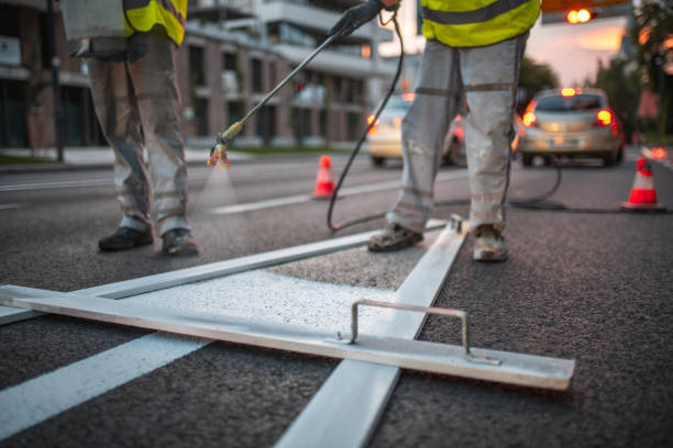 Close Up On A Spray Gun And A Pointy Arrow Stencil For Spray Painting The Road Close up on a spray gun and a pointy arrow stencil for spray painting the road. One worker using a spray gun. They are all wearing a reflective vest. freshly painted road markings stock pictures, royalty-free photos & images