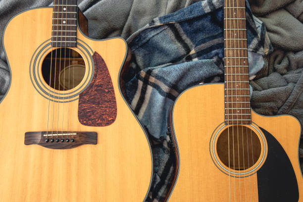 istock Two acoustic guitars on a cozy plaid, top view. 1420992573