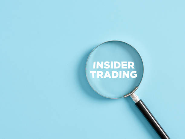 Magnifier with the text insider trading on blue background.