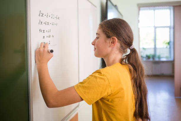 istock teenager child student solves the equation on blackboard in school classroom in math algebra lesson in middle link 1420997419
