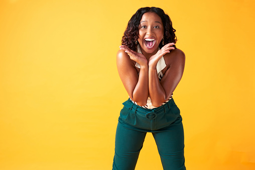 Amazed, young and happy black woman screaming while standing in studio with copy space. Portrait of winner full of energy with a surprised, wow and omg face. Girl shocked by store sale and discount.