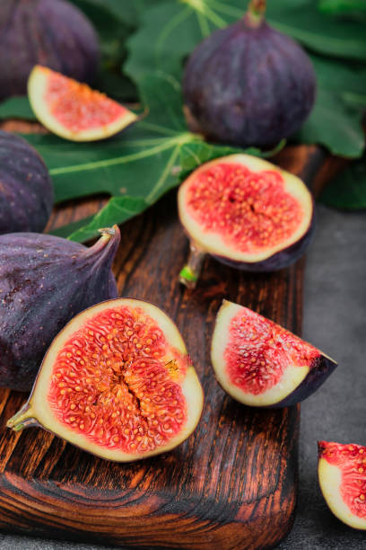 istock Figs cut into slices on a wooden cutting board close-up, selective focus. Vertical frame seasonal ripe fruits, mediterranean diet, idea for background 1420998145