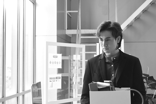 sadness Asian business man holding stuff in box after fired out and loss job in office room