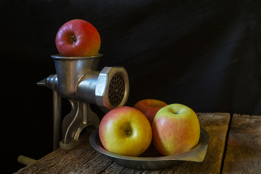 Still life with kitchen equipment and ripe fruit. Objects on a black background close-up
