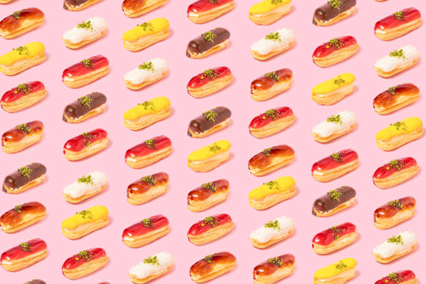 istock Pattern of assortment of eclairs with different topping on pink background. Differentiation and variability concept 1421005853