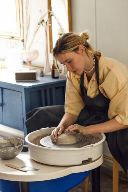 istock Young woman making pottery in her art studio 1421010044