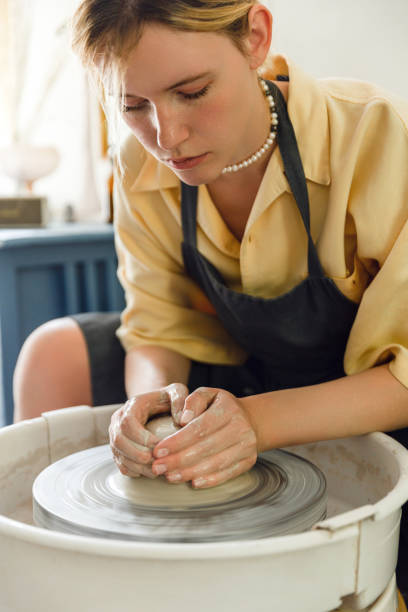 istock Female potter making ceramic vase on potter's wheel 1421010060