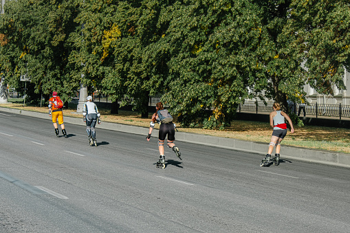 Ekaterinburg, Russia - August 7, 2022: man and women rollerblading on city street