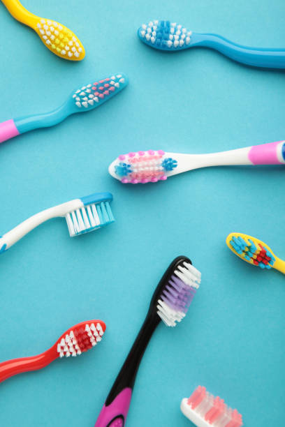 istock Colorful toothbrushes on blue background. Vertical photo 1421018264