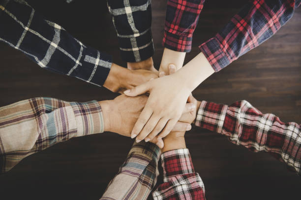 istock young business people putting their hands together 1421020452