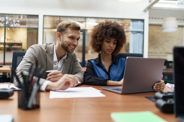 istock Two businesspartners working together in modern coworking and looking laptop 1421022341