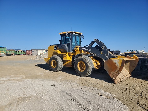 Superior, Colorado, USA-September 4, 2022: John Deere loader parked at a large construction site under development.