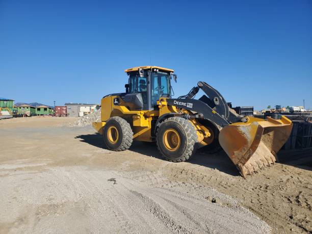 John Deere front end loader parked at a large construction site. stock photo