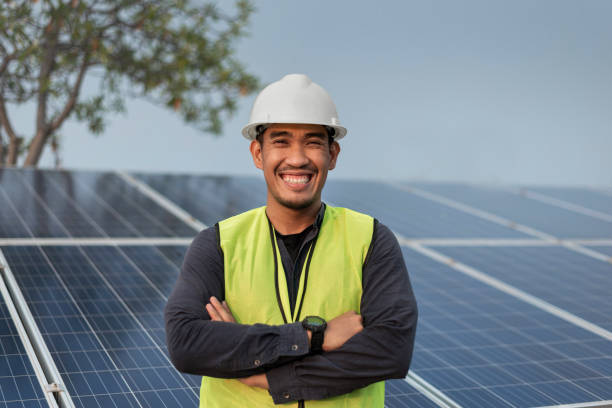 istock Engineer man standing and smiling with arms crossed with solar panels energy. Technician checking and services of photovoltaic solar panels. Sustainable Energy concept. 1421023460