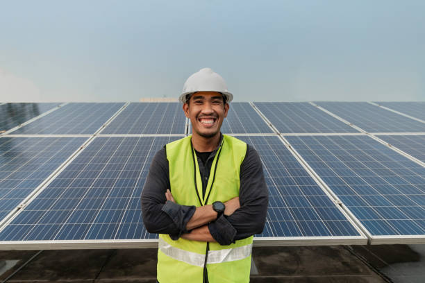 istock Engineer man standing and smiling with arms crossed with solar panels energy. Technician checking and services of photovoltaic solar panels. Sustainable Energy concept. 1421023661