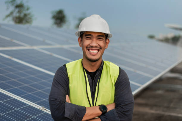 istock Engineer man standing and smiling with arms crossed with solar panels energy. Technician checking and services of photovoltaic solar panels. Sustainable Energy concept. 1421024441