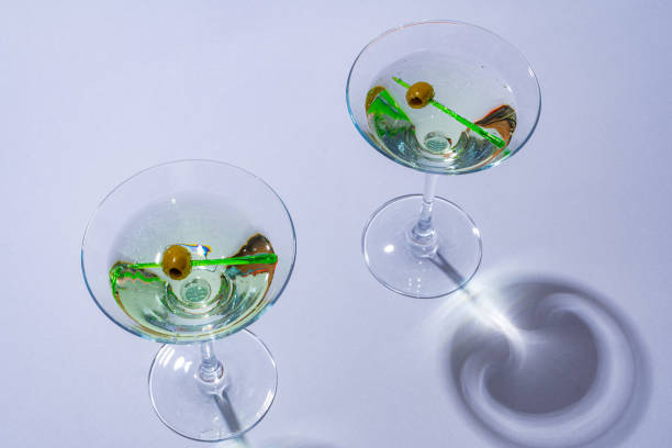 istock Two classic dry martini with olives on color background. 1421024984