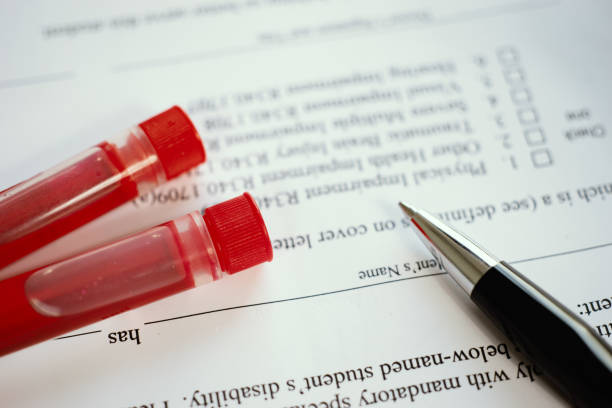 Medical doctor and blood sample and making notes with pen writing on prescription,lab technician DATA stock photo