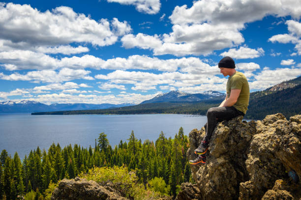 Hiker enjoying the view of Lake Tahoe from the Eagle Rock in California Hiker enjoying the view of Lake Tahoe from the Eagle Rock in California, with Sierra Nevada Mountains in the background. eagle rock stock pictures, royalty-free photos & images