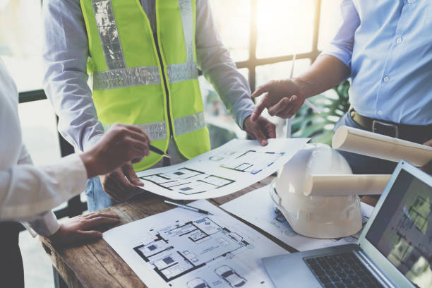 istock Construction and structure concept of engineer working drawing on blueprint meeting for project working with partner on model building and engineering tools in working site, construction concept 1421028925
