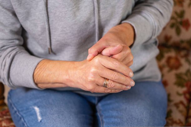 Senior woman suffering from hand and finger joint pain, inflammation stock photo