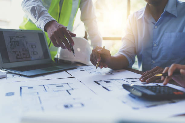 istock Construction and structure concept of engineer working drawing on blueprint meeting for project working with partner on model building and engineering tools in working site, construction concept 1421029710