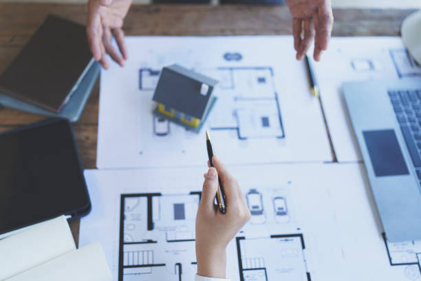 istock Construction and structure concept of engineer working drawing on blueprint meeting for project working with partner on model building and engineering tools in working site, construction concept 1421030136