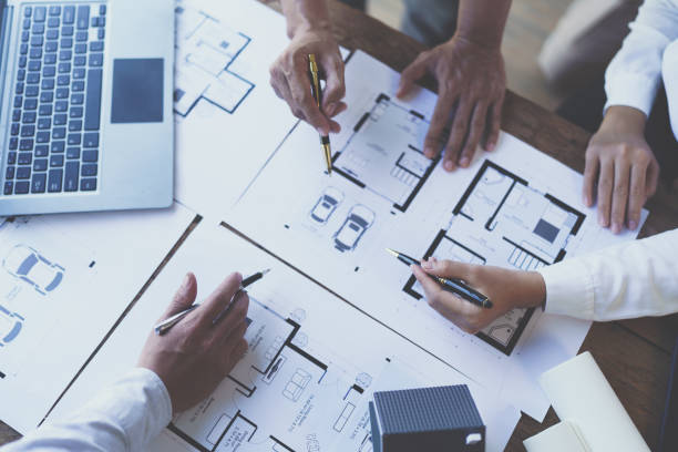 istock Construction and structure concept of engineer working drawing on blueprint meeting for project working with partner on model building and engineering tools in working site, construction concept 1421030219