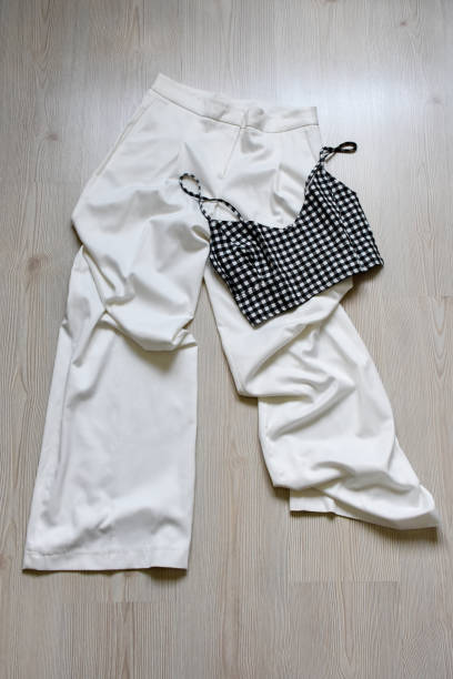여성 패션, 흰색 바지 및 민소매 블라우스가 나무 배경에 - 11992 뉴스 사진 이미지