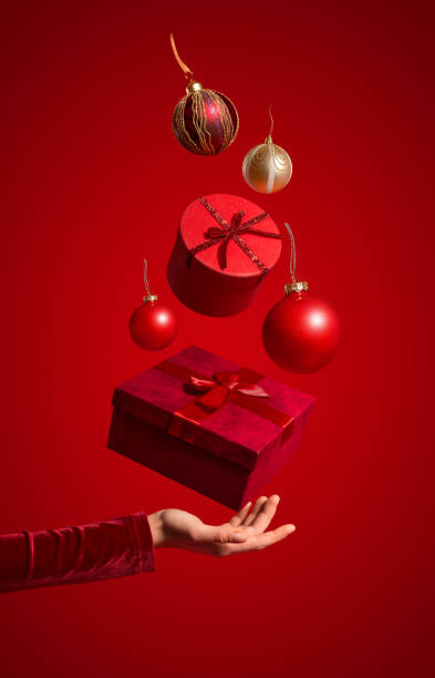 istock Hand holding a present and Christmas ornaments 1421032653