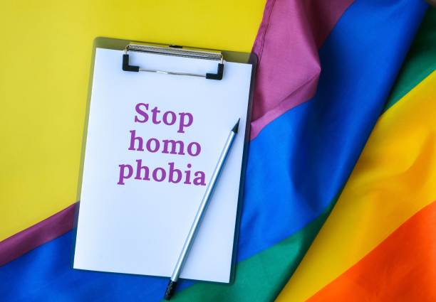 istock Rainbow flag with text STOP HOMOPHOBIA message paper note. Rainbow lgbtq flag made from silk material. Symbol of LGBTQ pride month. Equal rights 1421034641