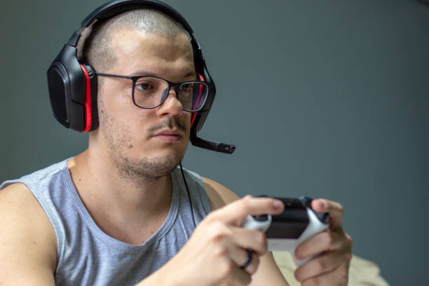 istock Gamerboy playing videogames with headphones 1421034761