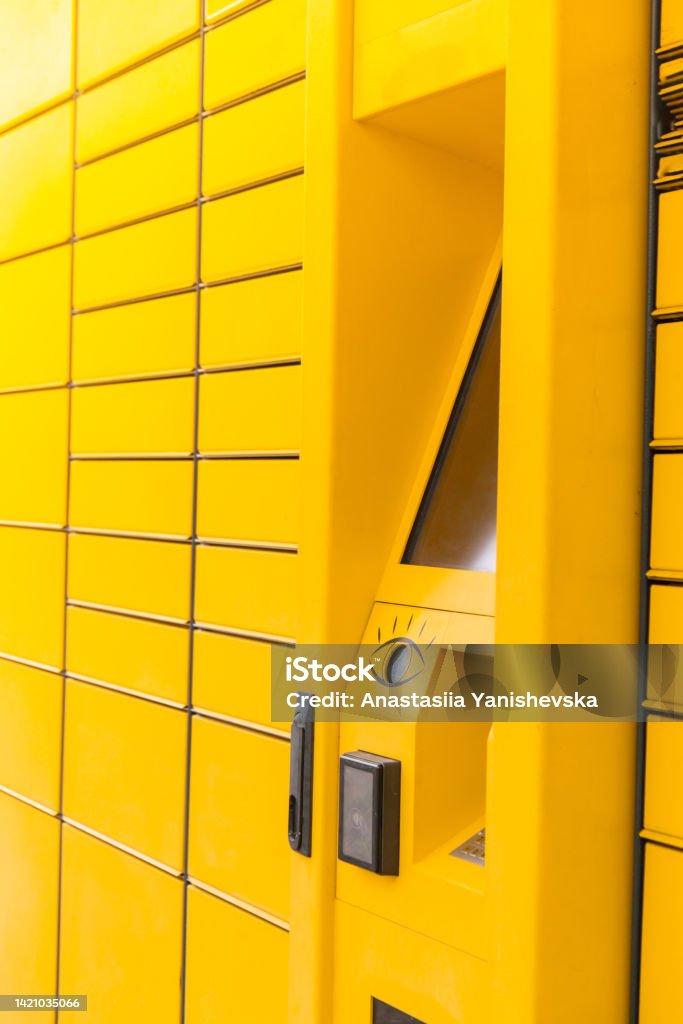 Modern yellow shopping locker. Bar code reader for Skans QR Code on Mobile phone Self-service Locker Cell Modern Shipping and Delivery Concept with Contactless Automated Postal Box. Parcel Locker Modern yellow shopping locker. Bar code reader for Skans QR Code on Mobile phone Self-service Locker Cell Modern Shipping and Delivery Concept with Contactless Automated Postal Box. Parcel Locker delivery service station Abstract Stock Photo