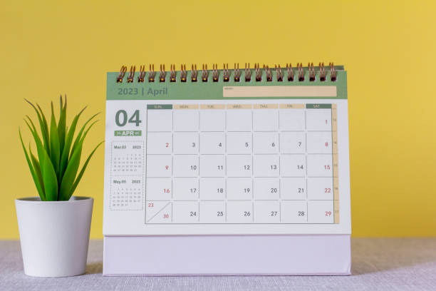 istock Desktop calendar for April 2023 on a yellow background. 1421036074