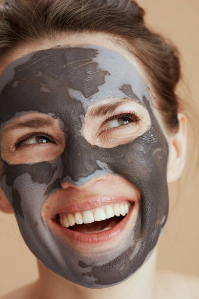 istock smiling modern woman with cosmetic mask 1421036404