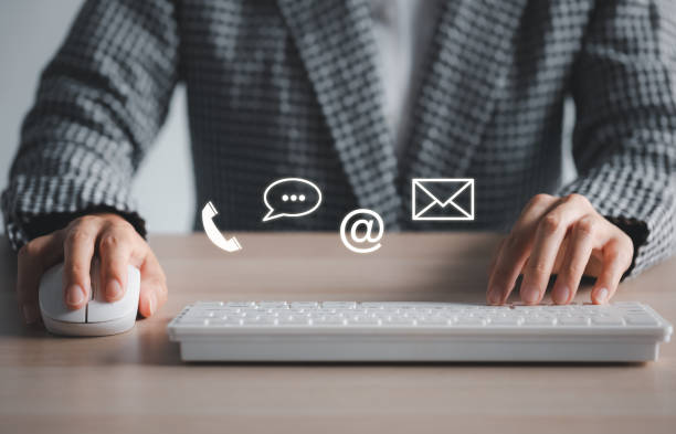 istock closeup woman using keyboard and mouse with phone, chat, address, mail icon above 1421038002
