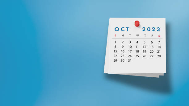 2023 October Calendar on Note Pad Against Blue Background 2023 October calendar on a white note paper pinned on wall against blue background. High resolution and copy space for all your crop needs. october stock pictures, royalty-free photos & images