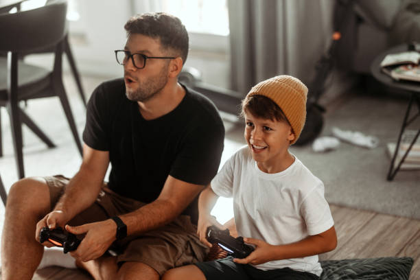 istock Father and son playing video games at home 1421043394